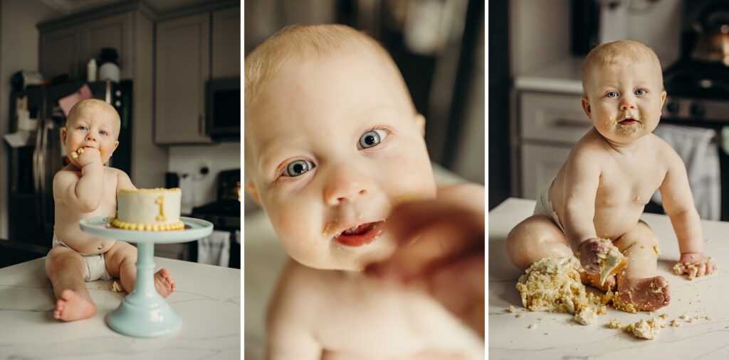 a collage of 3 images, show a baby sitting on a marble island all in a modern kitchen. the first photo is of a baby stuffing cake into his mouth as he looks into the camera. There is a blue cake stand in front of him that holds a yellow & white cake that has the number one on it. The 2nd photo is a close up of the same baby, as he reaches for the camera. There are cake crumbs all over his mouth. The last  photo show the baby now absolutely covered in cake. He is looking into the camera, as a pile of cake sits between his feet. 