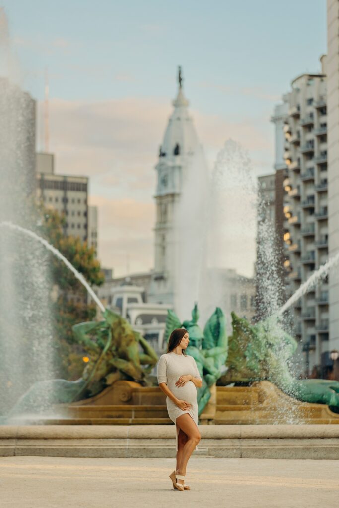 a pregnant woman posing in front of Logan Square in Center City Philadelphia during her maternity session. 