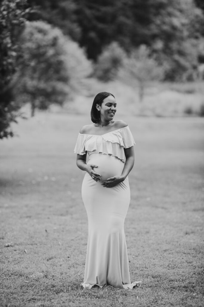 a pheonixville maternity session photo of a pregnant woman smiling looking away from the camera 