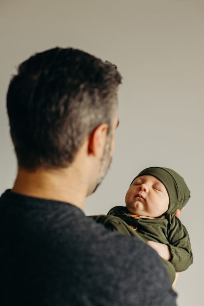 a new father holding his newborn son in a lifestyle session in Fishtown, Philadelphia 
