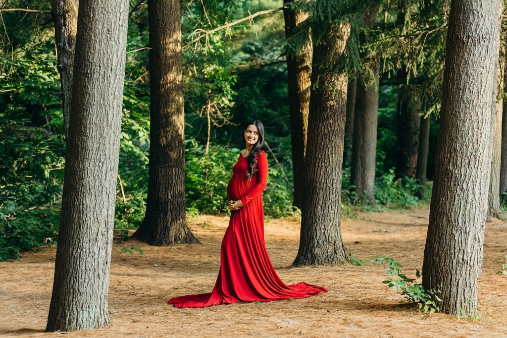 woman's maternity photoshoot in Lorimer ParkNortheast Philadelphia in a red gown
