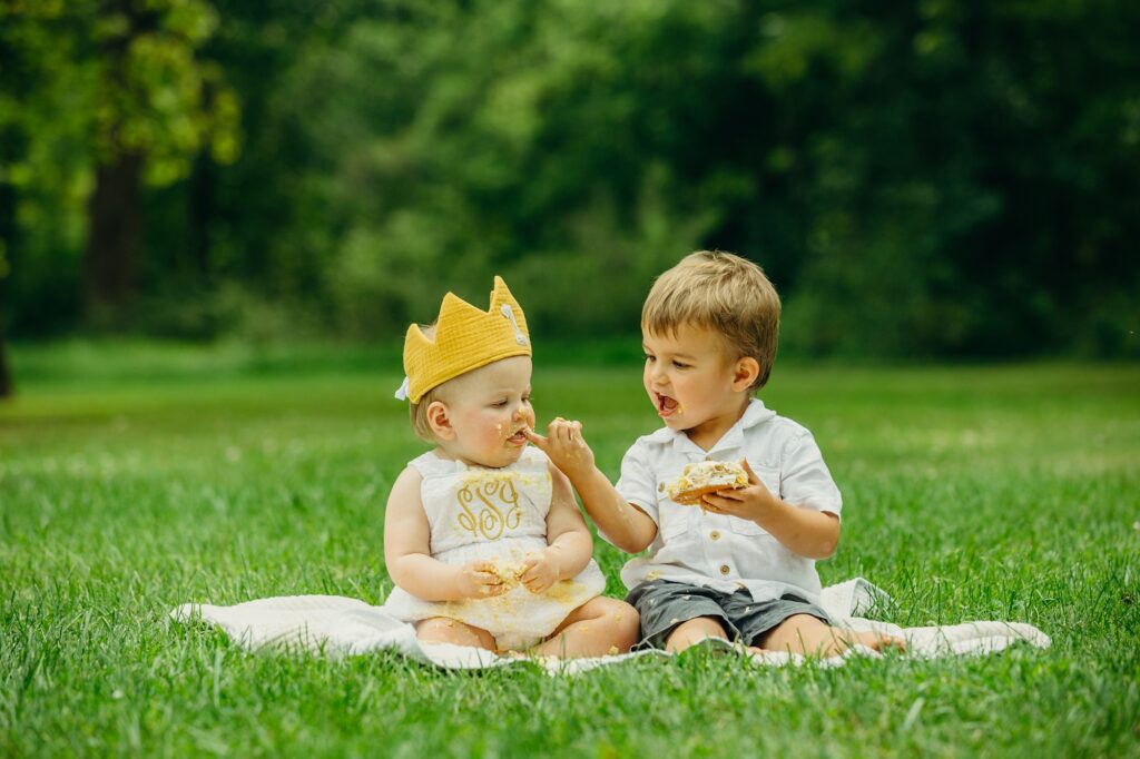 big brother feeding his baby sister her birthday cake during Philadelphia lifestyle cake smash 