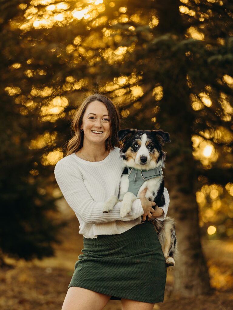 woman and her mini australian shepherd during a Pennsylvania Christmas tree farm photoshoot 