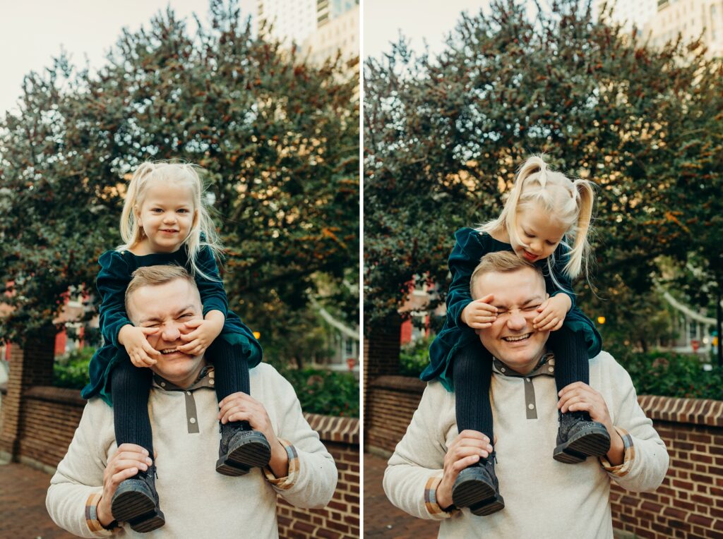 a little girl sitting on her dads shoulders during a lifestyle Christmas photoshoot in Center City Philadelphia 