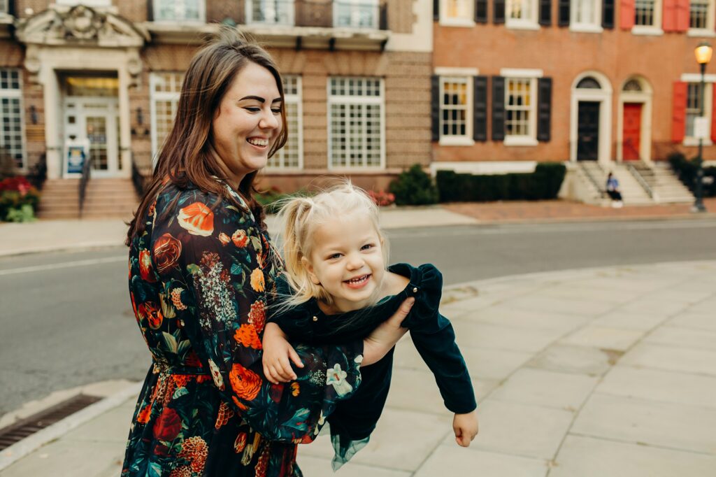 a little girl being held by her mother during a lifestyle Center City Philadelphia family photoshoot during the Christmas season 