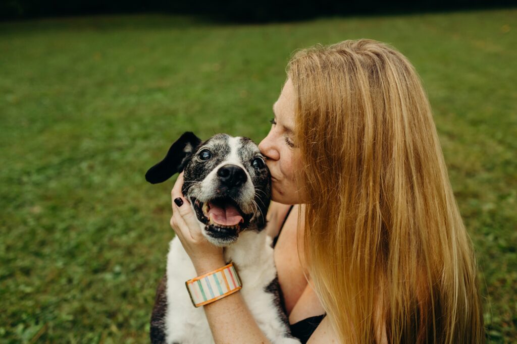 Philadelphia woman kissing her dog during summer pet photo session 