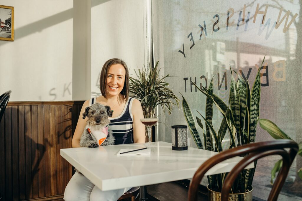 a Philadelphia woman at a cafe with her dog drinking an espresso martini 