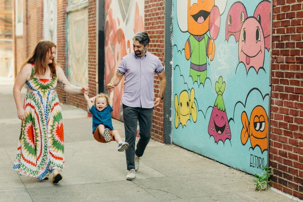 A family in Philadelphia strolling through Fishtown during the family photo session during the summer. 