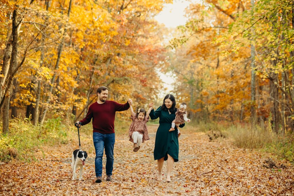 A family of four walking their dog during a Fall lifestyle family photoshoot in New Jersey.
