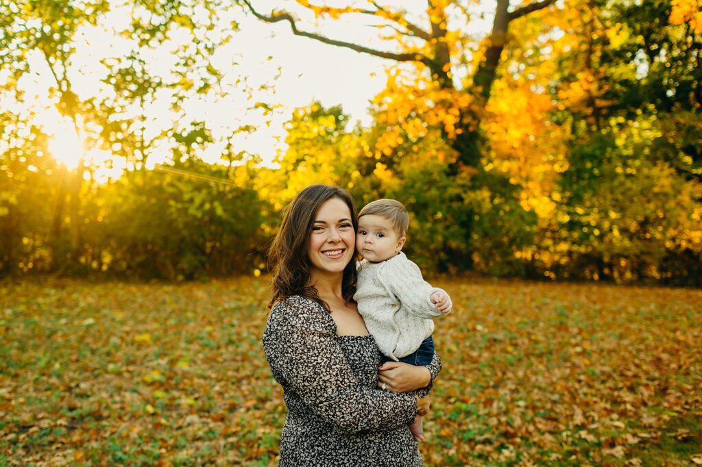 Sunset family photo session during the fall season with a mother and her baby boy in a dog friendly Philly park. 
