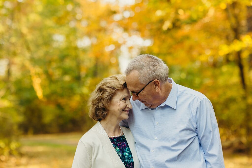 an elderly couple embracing one another during a fall family photoshoot in Philadelphia. 
