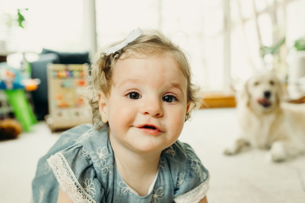 a one year old girl and her pet golden retriever during an at home family photoshoot in Center City Philadelphia 