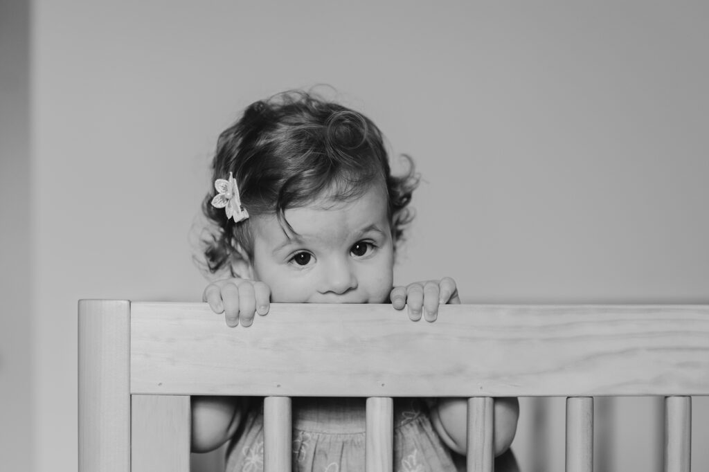 a one year old baby girl in her Philadelphia nursery during a lifestyle at home family photo session for her first birthday 