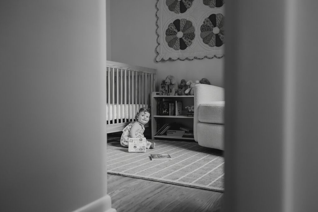 a one year old baby girl playing in her Center City Philadelphia nursery during an indoor family session 