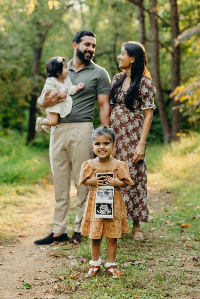 a pregnancy announcement photoshoot with two older siblings in Wissahickon Park in Philadelphia, PA 