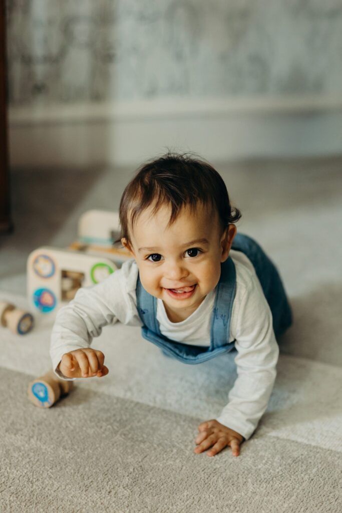 a baby boy crawling in his Norristown, PA nursery during a family photoshoot