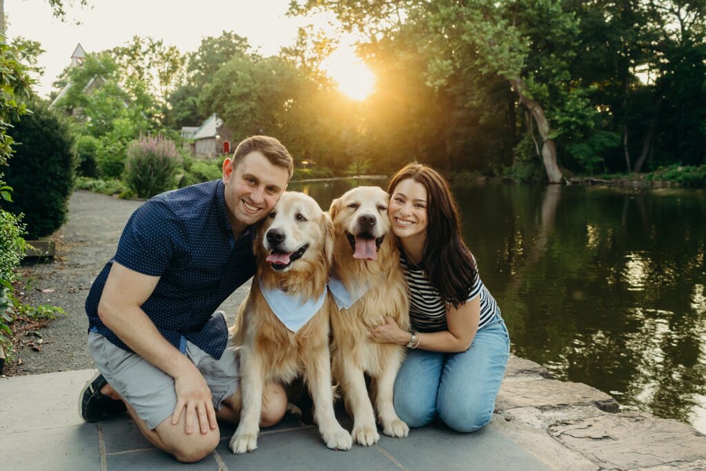 a young Yardley couple with their two pet golden retrievers in Yardley, Pennsylvania during a summer photoshoot. 