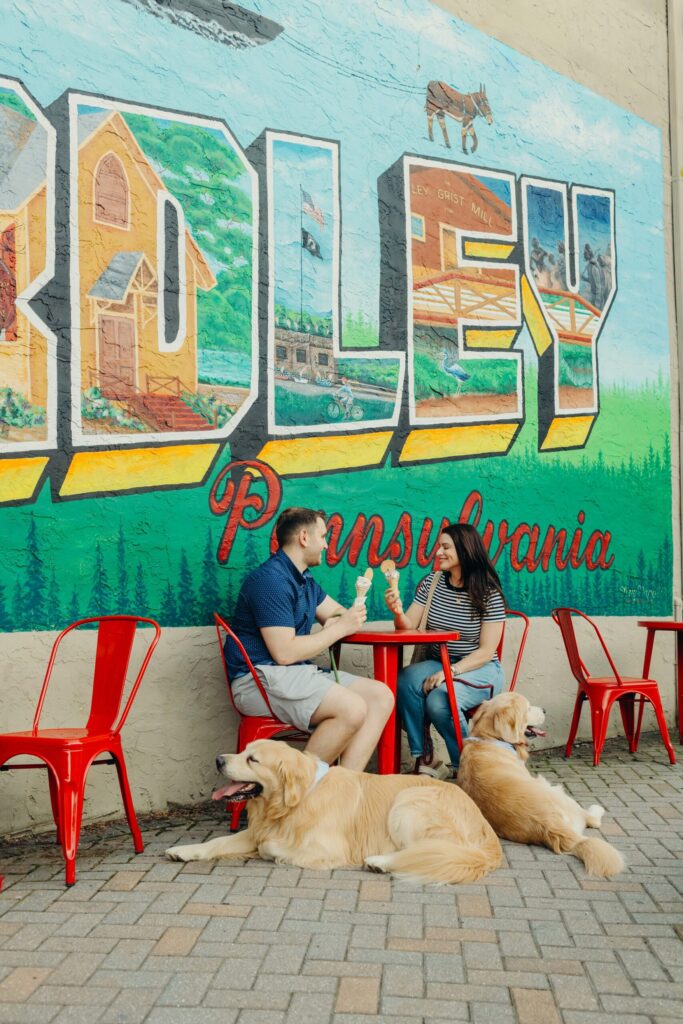 a Pennsylvania couple enjoying ice cream in Yardley with their two golden retriever dogs during a lifestyle pet session 