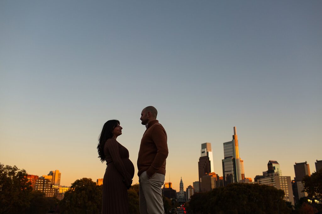 stunning silhouette of a Philadelphia woman during her lifestyle maternity session in front of the skyline during sunset